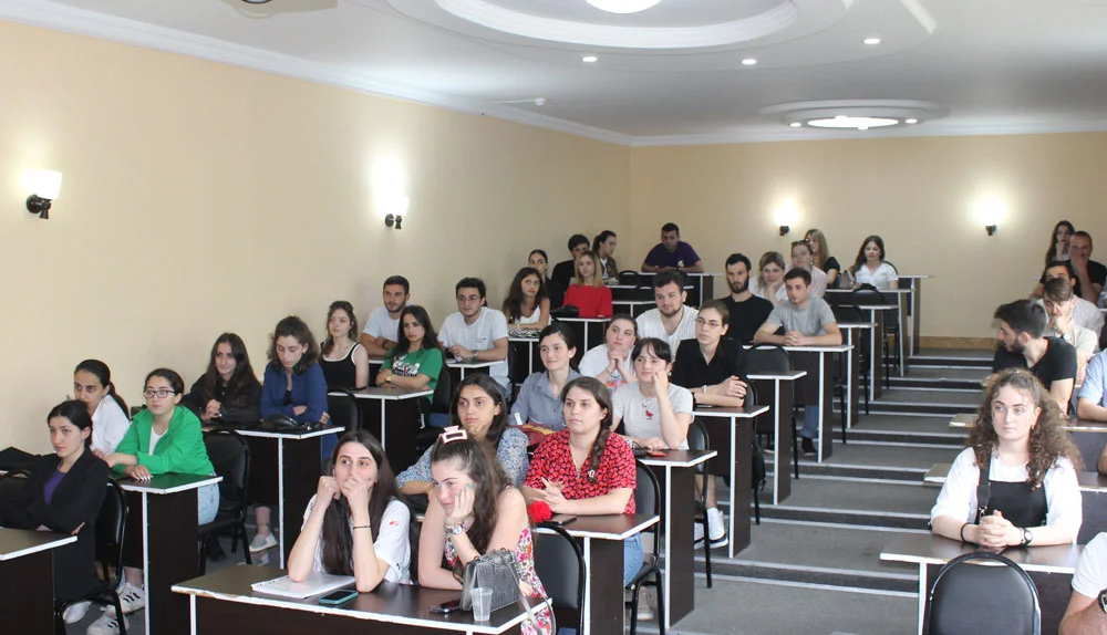 a group of GRUNI students sitting at desks in a classroom